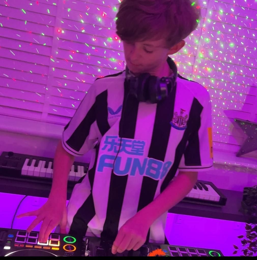 Newcastle DJ Zac Harris on the decks in a Newcastle shirt